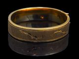 a close up of a gold ring on a black surface