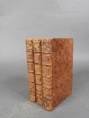trois vieux livres sont empilés sur une table