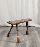 Tabouret bas tripode en chêne sculpté.