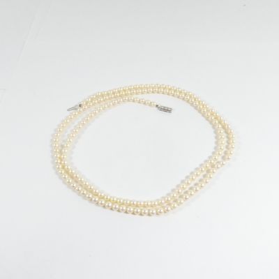 gros plan d'un collier de perles blanches sur une surface blanche
