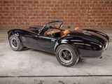 an image of a black sports car parked in front of a brick wall