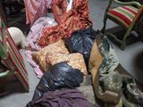 un tas de vêtements par terre, à côté d'une chaise