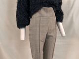 an image of a mannequin wearing a black sweater and plaid pants