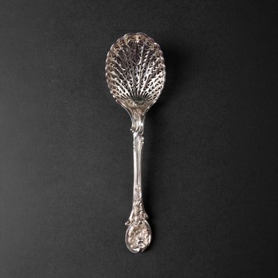a close up of a silver spoon on a black surface