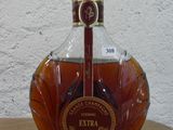 une bouteille de brandy posée sur une table en bois devant un mur blanc