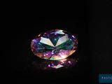 un gros plan d'un diamant coloré sur une surface noire