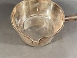 a silver bowl with a spoon in it on a table