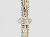 une croix en argent surmontée d'un crucifix, posée sur un socle