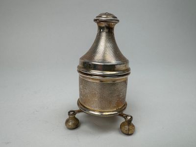 une théière ancienne en métal argenté avec couvercle, posée sur un socle