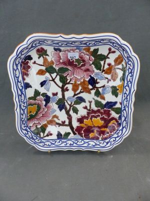 une image représentant une assiette décorative ornée de fleurs et de feuilles