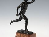 an image of a bronze statue of a man running on a marble base