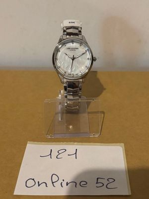 une montre posée sur un présentoir, avec une étiquette de prix accrochée dessus