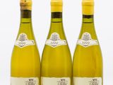 trois bouteilles de vin blanc posées l'une à côté de l'autre sur une surface blanche