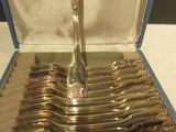un ensemble cuillère et fourchette en argent présenté dans une boîte bleue