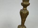 a gold candle holder with a clock on top of it