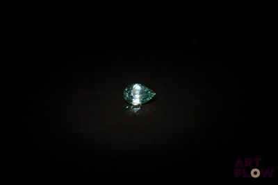 un gros plan sur un diamant vert dans l'obscurité