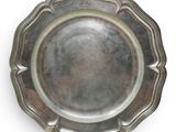 an antique silver plate with a gold handle on a white background