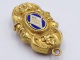 a gold pendant with a blue and white design on it