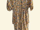 the dress is yellow and black with flowers on it