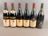 six bottles of wine are lined up in a row on a table