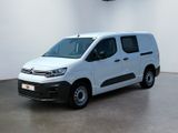 La camionnette blanche est garée dans une grande pièce blanche.