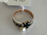 an image of a ring with pearls and a tag on a table