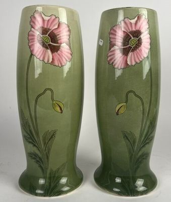 une paire de vases verts ornés de fleurs roses sur fond blanc
