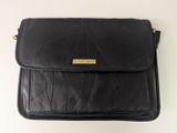 un sac à main en cuir noir orné d'une boucle dorée sur le devant