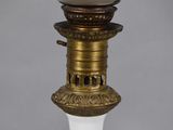 an antique lamp with a white glass shade on top of it