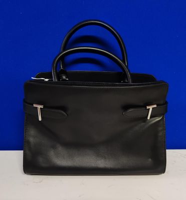 un sac à main en cuir noir posé sur une table blanche