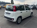 a small white car that is parked in a parking lot