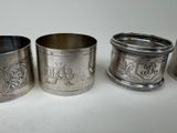 three silver napkins and a napkin holder on a white surface