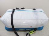 un sac de voyage blanc et bleu posé par terre