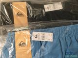two pairs of men ' s swim trunks are wrapped in plastic