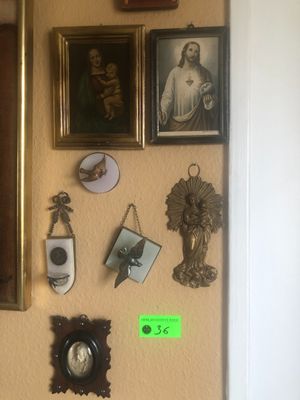 une photo d'un mur sur lequel sont accrochés des tableaux et une horloge