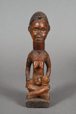 a wooden statue of a woman holding a baby in her arms