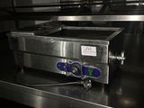 un plan de travail en acier inoxydable surmonté d'un four, dans une cuisine professionnelle