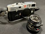 a black camera and a silver camera on a table