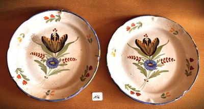 two plates with flowers painted on them on a table