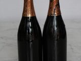 two bottles of champagne sitting on top of a marble counter top