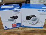 two boxes of omron blood pressure monitors sitting on a table