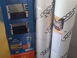 several rolls of paper are stacked on top of each other in front of a shelf