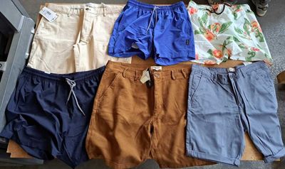Plusieurs paires de shorts pour hommes sont disposées sur une table