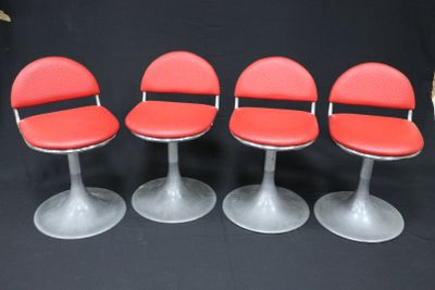 quatre chaises rouges alignées sur une surface noire
