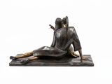 statue of a woman sitting on a mat with a cigarette in her mouth