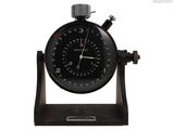 un chronomètre noir posé sur un socle en bois, sur fond blanc