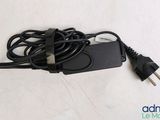 a close up of a charger on a white surface with a cord