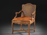 une chaise ancienne en bois avec une assise et des accoudoirs en cuir marron
