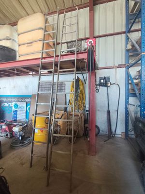 une photo d'un garage avec une échelle et un espace de travail