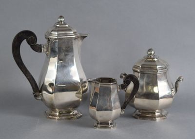 three pieces of silver tea and coffee set on a grey background